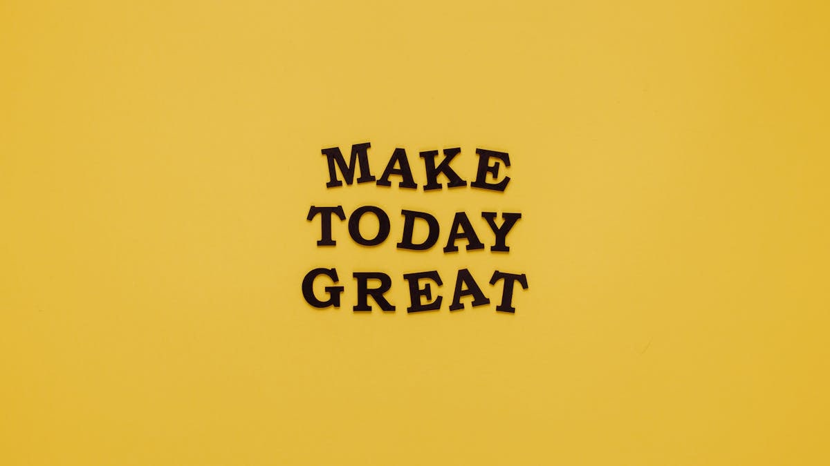 Simple and motivational quote 'Make Today Great' on a minimalist yellow background for inspiration.
